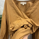 Prototype n°014 détail de l'encolure croisée, du tissu ocre doré et de l'étiquette XXL