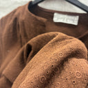 Détail du tissu chocolat à petits motifs brodés ton sur ton et ajours de la robe prototype n°021