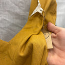 Prototype n°036, détail du tissu tissé ocre et de l’étiquette indiquant la taille S