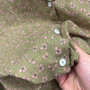 Prototype n°040, détail de l’imprimé à petites fleurs roses sur fond kaki et des boutons clairs cerclés de doré au poignet