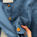 Prototype n°060 : détail du lin bleu navy, des boutons ambrés et de l’étiquette indiquant la taille M