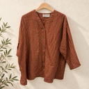 Prototype – Chemisier rayé à col V – Rouille et chocolat – XXL – N°076 — fond écru, cintre en bois et branches d’olivier