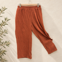Prototype – Pantalon à taille élastiquée – Terracotta – XXL – N°077 — fond écru, cintre en bois et branches d’olivier