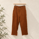 Prototype – Pantalon léger – Lin marron – S – N°094 — fond écru, cintre en bois et branches d’olivier