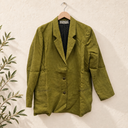 Prototype – Veste de costume – Lin vert kiwi – S – N°100 — fond écru, cintre en bois et branches d’olivier